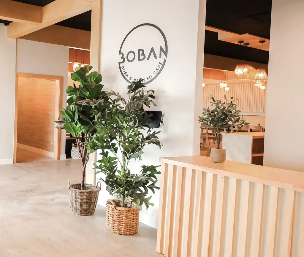 Modern cafe interior with plants and wooden decor
